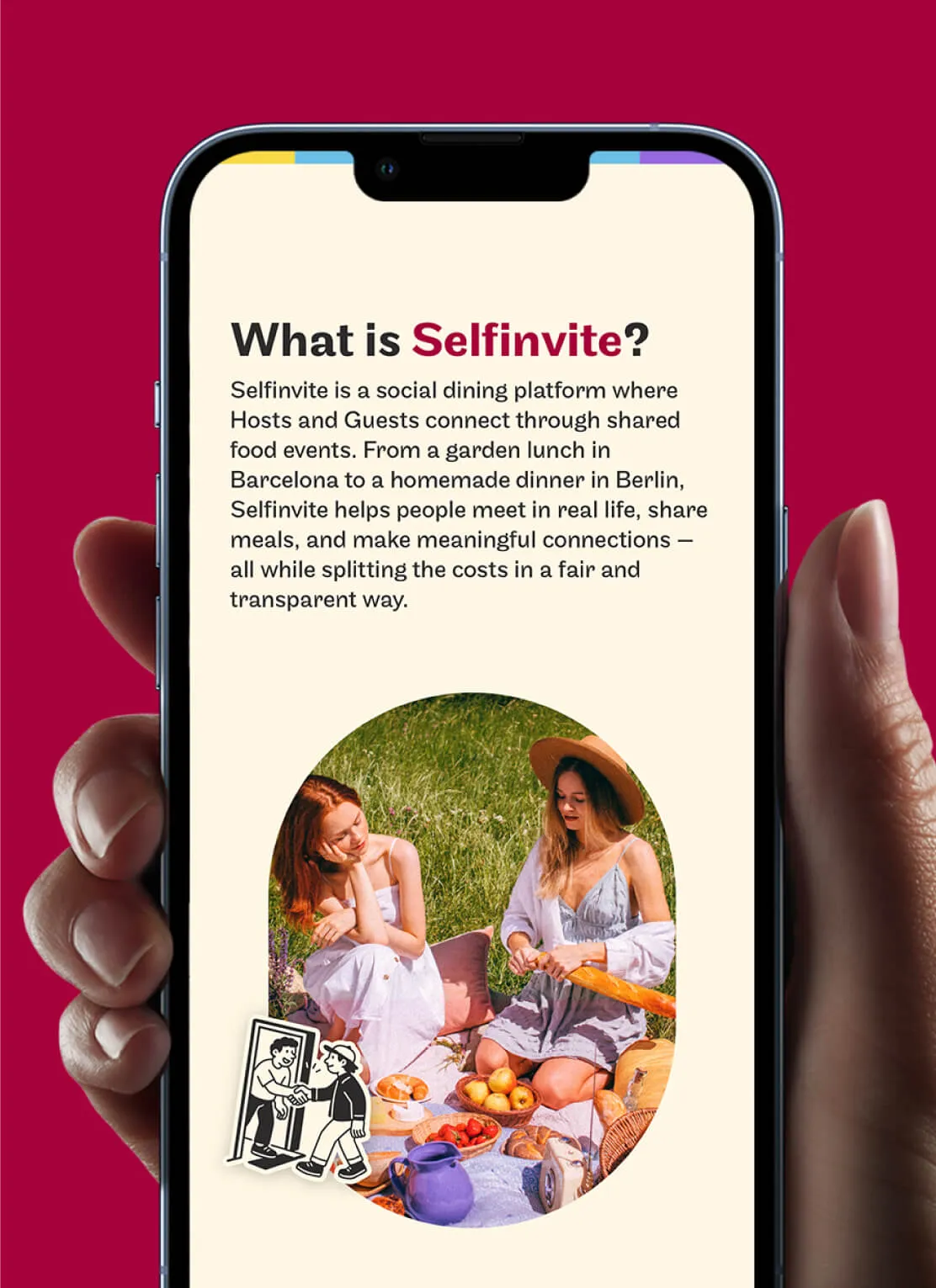 Smartphone held by a hand displaying text explaining Selfinvite as a social dining platform where hosts and guests connect through shared food events to meet, share meals, and split costs fairly. Below the text is a circular photo of two women sitting on a picnic blanket in a grassy field with various picnic foods like bread, fruit, and a jug. A small illustration of two people shaking hands is near the bottom left of the circle.