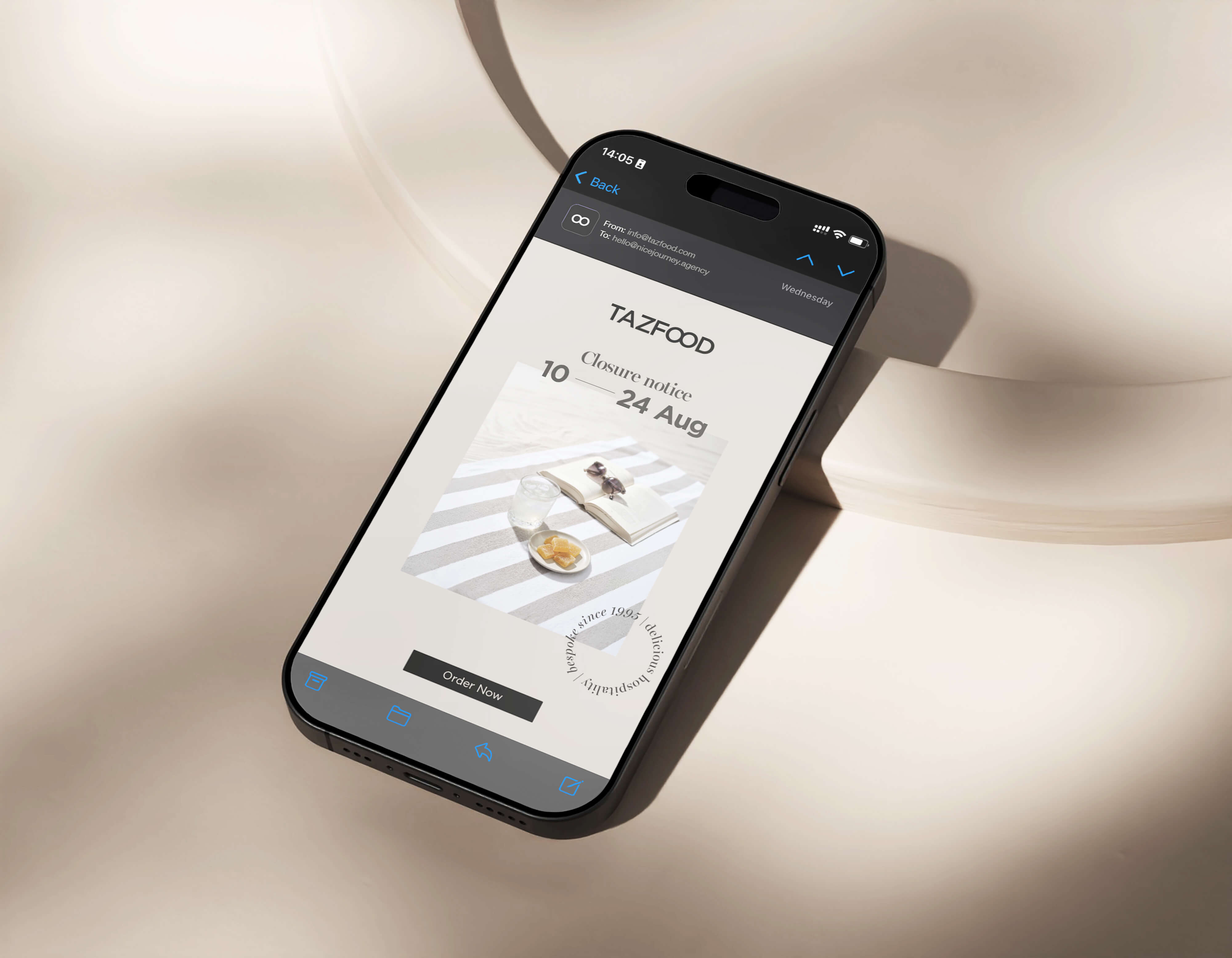 Smartphone displaying an email from TAZFOOD announcing a closure notice from August 10 to August 24, with a photo of a striped cloth, glass of water, plate with food, an open book and sunglasses, and a black 'Order Now' button.